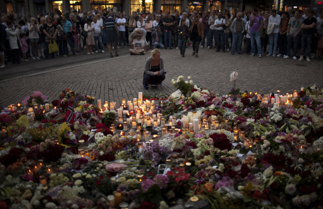 People gather during a candle light vigil to pay tribute to victims of the twin attacks near the Domkirke church on Friday, in central Oslo, Norway, Saturday, July 23, 2011. A massive bombing Friday i