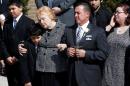Rosemarie Colvin, the mother of journalist Marie Colvin, embraces a youth as her casket is is carried out of her funeral service as her looks on at St. Dominic's Church in Oyster Bay, New York