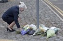 A woman places flowers outside the Royal Military Barracks, near the scene where a British soldier was killed in Woolwich, southeast London