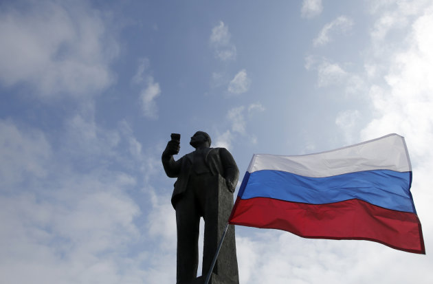 A Russian flag waves next to a statue of Soviet revolutionary leader Vladimir Lenin. (AP Photo/Darko Vojinovic)