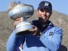Kuchar of the U.S. holds the trophy after beating Hunter Mahan 2&1 during the championship match of the WGC-Accenture Match Play Championship golf tournament in Marana