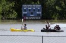 A kayaker pulls a raft with children around a flooded baseball park in San Antonio, Saturday, May 25, 2013, in San Antonio. San Antonio International Airport recorded more than nine inches of rain since midnight. (AP Photo/Eric Gay)