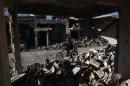 A Syrian man rides his bicycle among destroyed buildings in the rebel-held town of Douma, on the outskirts of the capital Damascus, on March 7, 2016
