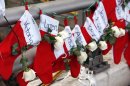 FILE - In this Wednesday, Dec. 19, 2012 file photo, Christmas stockings with the names of shooting victims hang from railing near a makeshift memorial near the town Christmas tree in the Sandy Hook village of Newtown, Conn. In the wake of the shooting, the grieving town is trying to find meaning in Christmas. (AP Photo/Julio Cortez, File)