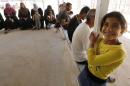 Syrian refugees wait to call their relatives at a centre of the International Committee of The Red Cross which conducts a programme that enables refugees to get in touch with their relatives at Al Zaatari refugee camp