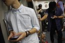 Commuters use their smartphones in a train in Singapore