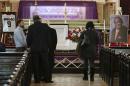 Mourners pass by the casket of former Chicago White Sox great Minnie Minoso on Friday, March 6, 2015, to pay their respects during a public visitation at Holy Family Church in Chicago. The Havana native and major league baseball's first black Latino star died Sunday, March 1. He was believed to be 90. Known as the "Cuban Comet," Minoso was part of a wave of black players who transformed the game. (AP Photo/M. Spencer Green)