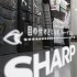 A man is reflected on Sharp's logo on its fridge at an electronic shop in Tokyo