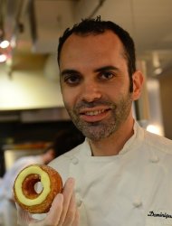 French pastry chef Dominique Ansel poses with a cronut at his bakery shop in New York on June 14, 2013. Ansel has become accustomed to queues of 150 to 200 people winding down the street before the bakery has opened