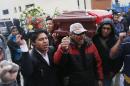 Municipal workers shouts slogans as they hold a coffin that symbolizes workers who died of asphyxiation when protesters set fire to the municipal building they were working in, in El Alto, Bolivia, Wednesday, Feb. 17, 2016. Several workers died of asphyxiation Wednesday and dozens were injured in the opposition-run highlands city of El Alto. The fire was ignited by protesters following a march by residents demanding better schools and more teachers. (AP Photo/Juan Karita)