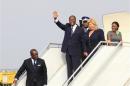 Ivory Coast's President Alassane Ouattara waves next to wife Dominique as they arrive at Felix Houphouet-Boigny international airport in Abidjan