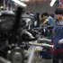 An employee works on a car engine along a Geely Automobile Corporation assembly line in Cixi