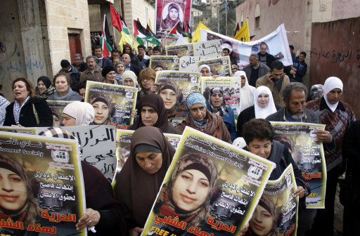 Palestinians take part in a protest in solidarity with Hana Shalabi, a Palestinian prisoner jailed in Israel and who has been on hunger strike for 18 days, in the West Bank village of Burqin near Jenin, Sunday, March 4, 2012. Palestinian sources said Shalabi is protesting against the Israeli administrative detention, a law imposed against Palestinian prisoners in which the prisoner can be detained for months without charge or trial. (AP Photo/Mohammed Ballas)