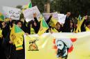 Iraqi Muslim Shiite women hold flags and a banner showing prominent Shiite cleric Nimr al-Nimr during a demonstration in Baghdad on January 6, 2016 against Nimr's execution by Saudi authorities