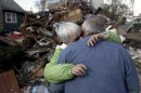 Sheila and Dominic Traina hug in front of their home which was demolished during Superstorm Sandy in Staten Island, N.Y., Friday, Nov. 2, 2012. Mayor Michael Bloomberg has come under fire for pressing ahead with the New York City Marathon. Some New Yorkers say holding the 26.2-mile race would be insensitive and divert police and other important resources when many are still suffering from Superstorm Sandy. The course runs from the Verrazano-Narrows Bridge on hard-hit Staten Island to Central Park, sending runners through all five boroughs. The course will not be changed, since there was little damage along the route. (AP Photo/Seth Wenig)