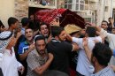 Mourners carry the coffin of Ali Abd al-Razzaq, 25, who was killed when a parked car bomb hit a coffee shop in the largely Sunni neighborhood of Azamiyah on Wednesday, in Azamiyah, Baghdad, Iraq, Thursday, Aug. 29, 2013. Car bomb blasts and other explosions tore through the Baghdad area Wednesday in a day of violence that killed and wounded scores of civilians, intensifying worries about Iraq's ability to tame the spiraling mayhem gripping the country. (AP Photo/Khalid Mohammed)