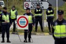 Police officers stand guard in a checkpoint near to the border of Spain and France in La Jonquera, Girona, Spain, Saturday, April 28, 2012. Spain has temporarily restored border checks in its northeast and at two major airports in a bid to stop protesters entering the country ahead of a European Central Bank meeting in Barcelona. Spanish authorities early Saturday suspended the Schengen Treaty which allows unrestricted travel inside member nations, and imposed controls at six border crossings with France and at Barcelona and Gerona international airports. (AP Photo/Emilio Morenatti)