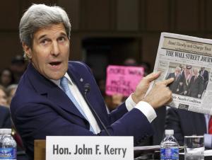 Secretary of State John Kerry points to a newspaper &hellip;