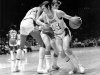 FILE - Los Angeles Lakers' Jerry West (14) is fouled as he tries to get around Houston Rockets' John Vallely after teammate Wilt Chamberlain set screen in game at the Forum in Inglewood, Calif., in this Dec. 27, 1971 file photo.  The Lakers went on to their 28th straight win, beating the Rockets 137-115.  (AP Photo, File)