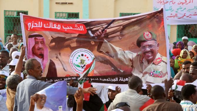 Supporters hold a banner during a campaign meeting for the incumbent Sudanese president and candidate for the National Congress Party Omar al-Bashir on March 31, 2015 in the capital Khartoum