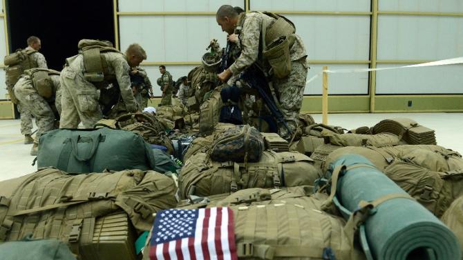 US Marines arrange their equipment as US troops arrive in Kandahar after their withdrawl from the Camp Bastion-Leatherneck complex in Helmand province on October 26, 2014