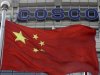 A Chinese national flag flies in front of COSCO's headquarters in Beijing