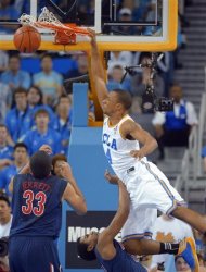 UCLA guard Norman Powell dunks over Arizona guard Jordin Mayes, below right, as forward Grant Jerrett watches during the first half of an NCAA college basketball game, Saturday, March 2, 2013, in Los Angeles. (AP Photo/Mark J. Terrill)