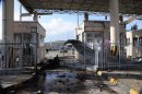 Man walks past a damaged gate after an explosion at Cilvegozu border gate on the Turkish-Syrian border in Hatay province