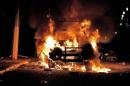 A truck on fire is seen near the place where two men were lynched and burnt to death by an angry crowd who accused them of kidnapping children, at the main square of Ajalpan, a town in Puebla, Mexico, on October 19, 2015