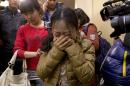 A Chinese relative of passengers aboard a missing Malaysia Airlines plane, center, cries as she is escorted by a woman while leaving a hotel room for relatives or friends of passengers aboard the missing airplane, in Beijing, China Sunday, March 9, 2014. Planes and ships from across Asia resumed the hunt Sunday for the Malaysian jetliner missing with 239 people on board for more than 24 hours, while Malaysian aviation authorities investigated how two passengers were apparently able to get on the aircraft using stolen passports. (AP Photo/Andy Wong)