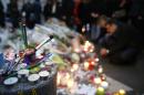 People light candles outside the offices of the French satirical newspaper Charlie Hebdo in Paris on January 10, 2015