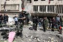 Syrian police inspect the damage outside the criminal police headquarters