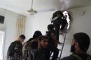 Free Syrian Army fighters climb up a ladder to walk through a hole in a wall during an offensive against forces loyal to Syria's President Bashar al-Assad, in Aleppo