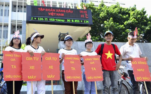 Students hold placards in a protest against petrol price hike in front of Petrolimex, in Hanoi