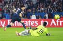 PSG soccer players Edinson Cavani , left, scores the winning goal past Reims' goalkeeper Kossi Agassa, during the French League One soccer Match between Paris Saint-Germain and Stade de Reims, at the Parc des Princes stadium in Paris, Saturday, May 23, 2015. Paris Saint-Germain clinched a third straight title. (AP Photo/Jacques Brinon)