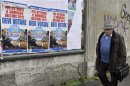A man walks past election campaign posters of PDL (People of Freedom) member Silvio Berlusconi in Milan