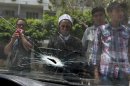 A supporter of deposed Egyptian President Mohamed Mursi looks at the damage to a car window after clashes near the Republican Guard headquarters in Cairo