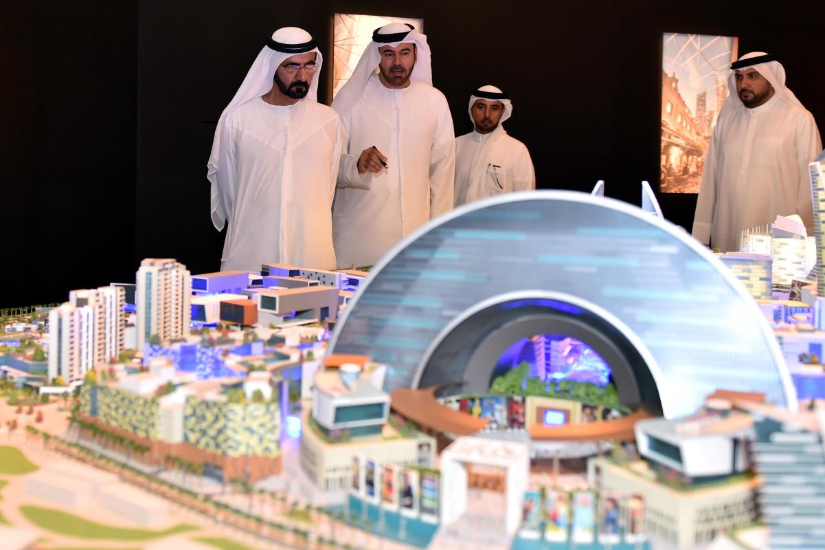 In this Saturday July 5, 2014 photo released by the Dubai Government Media Office, UAE Prime Minister and Dubai ruler Sheik Mohammed bin Rashid Al Maktoum, left, listens to Mohammed Abdullah Al Gergawi, center, Chairman of Dubai Holding during the presentation of a sprawling real-estate project known as the Mall of the World that is planned to include an 8 million square foot (743,224 square meter) mall, a climate-controlled street network, a theme park covered during the scorching summer months and 100 hotels and serviced apartments. The Dubai Media Office announced the project on Saturday but gave no details on the cost or the completion date. (AP Photo/Dubai Media Office)