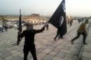 File photo of a fighter of ISIL holding a flag and a weapon on a street in Mosul