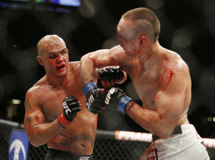 Rory MacDonald throws an elbow at Robbie Lawler during their welterweight title fight. (AP)