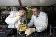This 2009 photo provided Tuesday Oct. 9, 2012 by the CNRS (Centre Nationale de la Recherche Scientifique) shows French physician Serge Haroche, right, and his aide Igor Dotsenko in Paris. Haroche and U.S David wineland share the 2012 Nobel Prize in physics Tuesday Oct. 9, 2012 for inventing methods to observe the bizarre properties of the quantum world, research that has led to the construction of extremely precise clocks and helped scientists take the first steps toward building superfast computers. (AP Photo/CNRS/ Christophe Lebedinsky) EDITORIAL USE ONLY - NO USE AFTER DEC.31 2012