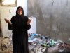 In this photo from Sunday, Aug. 5, 2012, Fatoum Obeid, 50, stands in a pile of trash left by Syrian soldiers who occupied her home in Atarib, Syria. In recent months rebels have seized a huge swath of territory in northern Syria, giving them a freedom to move and organize unprecedented in the 17-month conflict. (AP Photo/Ben Hubbard)
