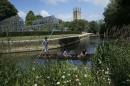 People punt on the river Cherwell past Magdalen College Tower in Oxford, southern England