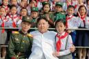 Schoolchildren stand beside North Korean leader Kim Jong Un as he arrives to attend "We Are the Happiest in the World", a performance of schoolchildren to celebrate the 70th founding anniversary of the Korean Children's Union
