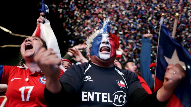 Fans of Chile celebrate their second goal against Peru while watching a broadcast of the Copa America semi-final soccer match at the Fan Fest in Santiago