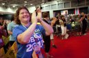 Wearing a shirt that says "Educators for Obama 2012," Marsha Fabian, a teacher, of Lancaster, Penn., claps during the National Education Association's annual convention in Washington, on Thursday, July 5, 2012. (AP Photo/Jacquelyn Martin)