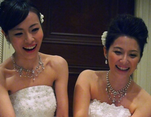 Lesbian couple Koyuki Higashi (L) and Hiroko light a candle at their wedding reception in Tokyo on March 1, 2013. They became the first gay couple to tie the knot at Tokyo Disney Resort, both decked out in fairytale white dresses despite an initial ruling that one had to wear men's clothes