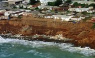 Homes which are sliding in to the sea in Pacifica, California are seen from the air, March 4. 1998. REUTERS/Sean Ramsey