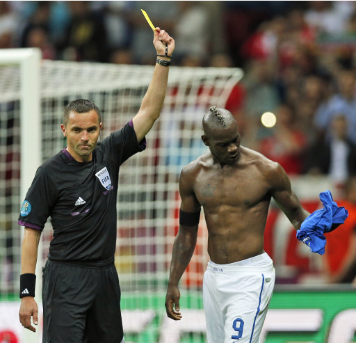 Italy's Mario Balotelli is awarded the yellow card by referee Stephane Lannoy of France during the Euro 2012 soccer championship semifinal match between Germany and Italy in Warsaw, Poland, Thursday, June 28, 2012. (AP Photo/Vadim Ghirda)