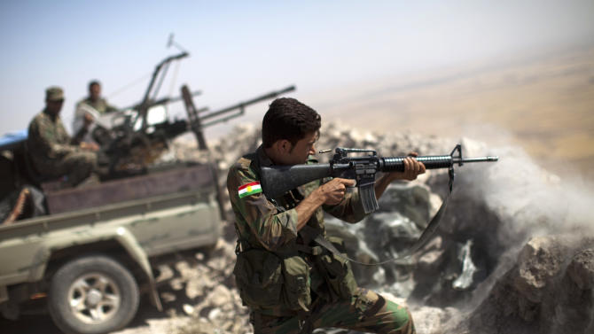 An Iraqi Kurdish Peshmerga fighter fires at Islamic-State (IS) militant positions, from his position on the top of Mount Zardak, a strategic point taken 3 days ago, about 25 kilometres east of Mosul on September 9, 2014